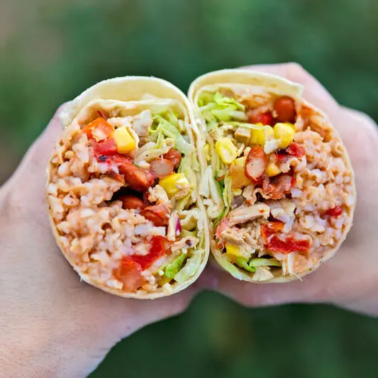 Hands holding two sides of a burrito